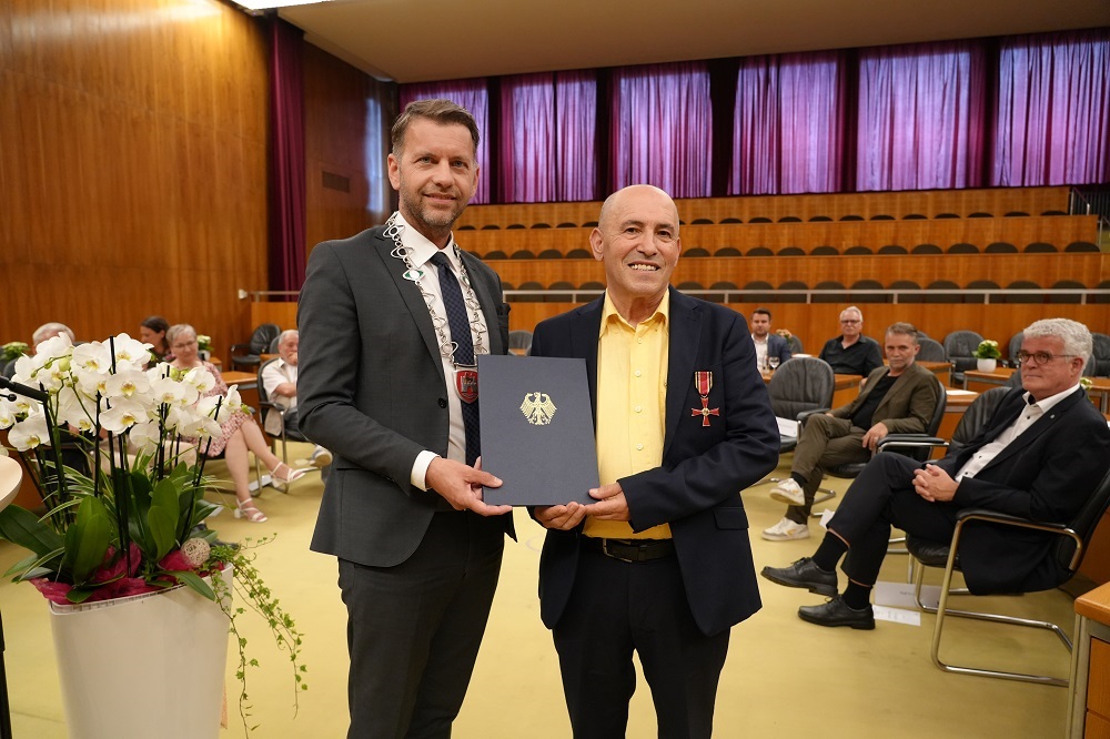 Mayor Dennis Weilmann presents Paolo Brullo with the Cross of Merit on Ribbon of the Order of Merit of the Federal Republic of Germany. 
